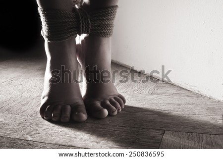 detail suspended bound feet submissive young girl on the floor / BDSM theme
