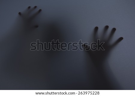 Shadowy figure behind glass / fear, panic concept