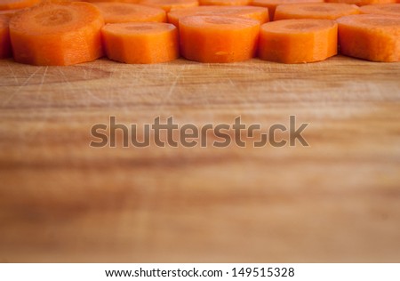 Sliced carrot against wooden chopping board background