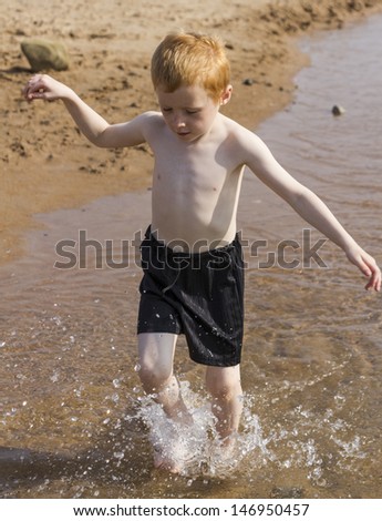 Six year old boy playing at seaside.