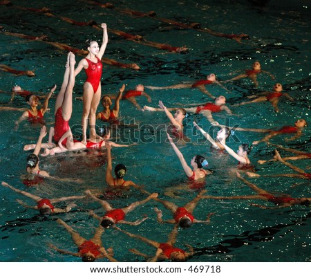 Person standing in victory pose on top of other swimmers
