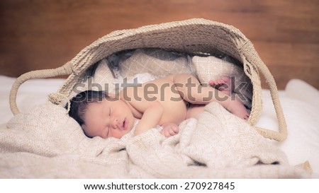 5 day old mixed race Asian Caucasian newborn baby boy sleeps peacefully on thick soft blankets.