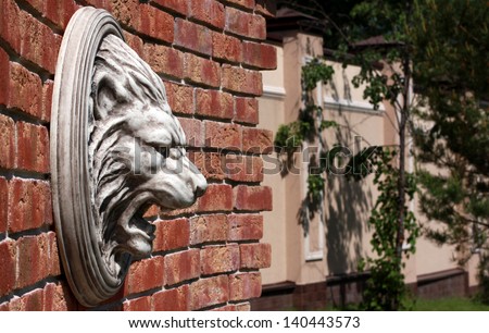 Bas-relief of the lion\'s head on a brick wall