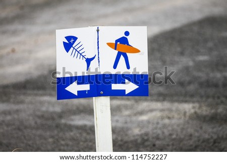Fish Surf Sign/ a sign post directing fisherman to park to the left and surfers the park to the right.
