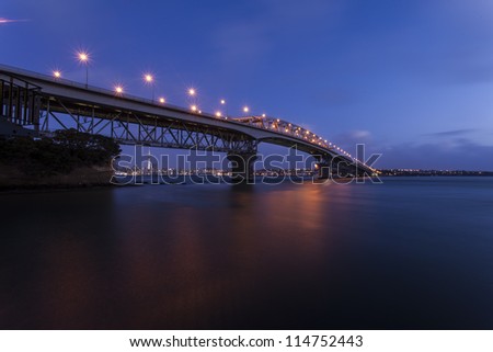 Auckland Harbor Bridge/ Auckland\'s iconic harbor bridge at dusk with the city lights in the background