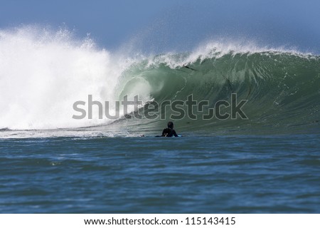 Wave Breaking/ a heavy powerful wave breaks with a body-boarder looking in to it