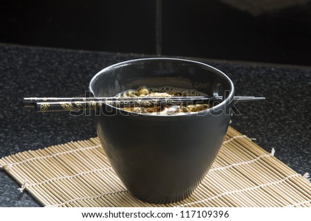 Chicken Noodles/ Chicken noodles presented in a black bowl with with matching chopsticks