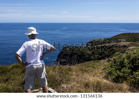 Senior Man/ at the top of an island overlooking the blue ocean