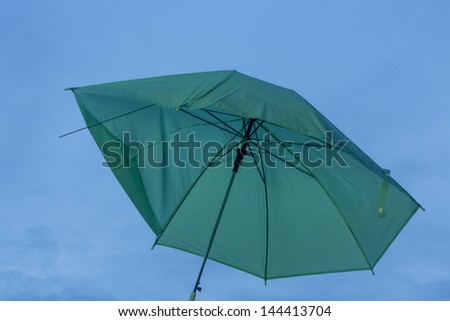 Broken Umbrella/ a green umbrella in the rain with stormy skies in the background