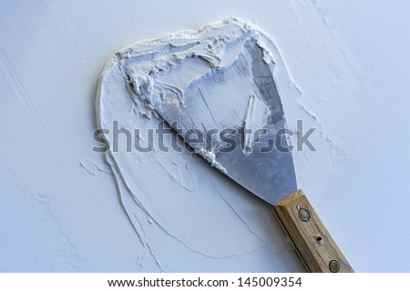 Plaster\'s trowel/ a plaster\'s trowel with plaster on a dry wall