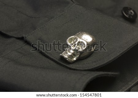 Skull Cuff Link/ A chrome skull cuff link on a black dress shirt