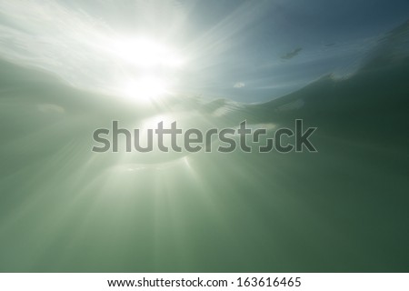 Underwater sun-flare/ shot just below the surface of the sea straight at the sun.