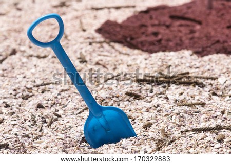 Blue Toy Spade/ a toy spade posed on a pink shelly beach