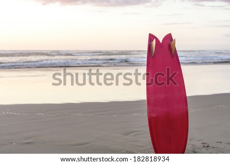 Red Retro Surfboard/ a retro styled surfboard standing on a west coast beach at sunset.