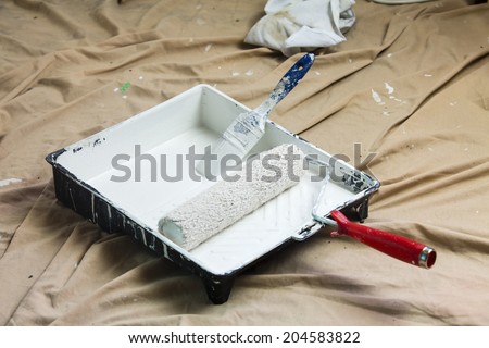 paint tray/ a paint tray, roller and paint brush with white paint