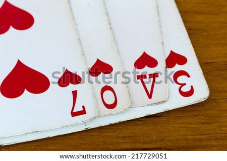 Love Cards/ The word love spelled out using the suit of Hearts out of a deck of playing cards.