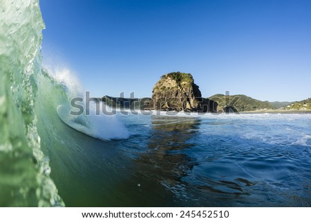 Lion Rock, Piha, NZ/ Iconic Lion Rock at Piha beach, shot from the water with a nice wave tubing