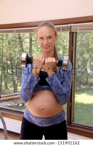 Beautiful young pregnant woman doing physical exercises.