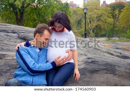 Beautiful young couple: pregnant  woman and her happy husband