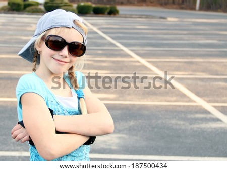 Funny little girl with the sunglasses and back to front cap