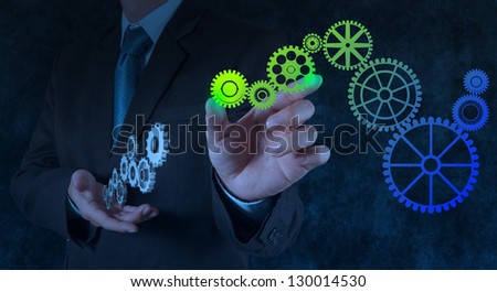 businessman hand draws gear to success concept on touch screen computer