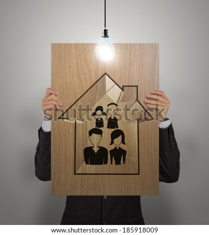 businessman show hand draw family and house on wooden poster as insurance concept