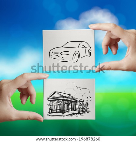 hand holding hand drawn house and car on canvas board on nature  background as concept