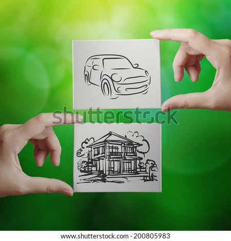 hand holding hand drawn house and car on canvas board on nature background as concept