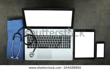 top view of workspace of medical with stethoscope and blue coat and blank screen computer laptop on texture desk background