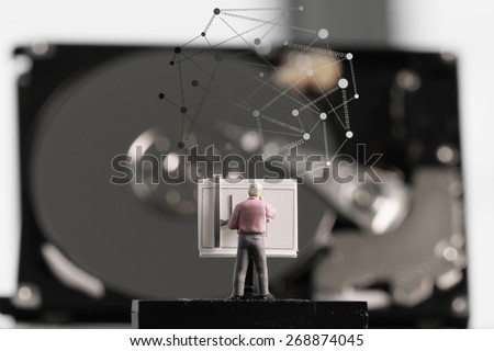 Big data concept-miniature engineer working with drafting table with open hard disk and  social network diagram