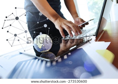 business documents on office table with texture the world on digital tablet and man using smart phone  in the background Elements of this image furnished by NASA