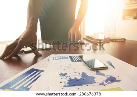Young creative designer man working at office and social network media and graph chart diagram as concept with overcast exposure effect
