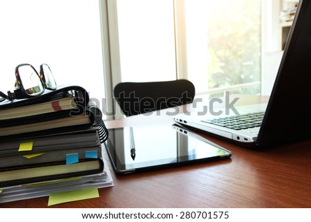 business documents on office table with smart phone and eye glass and modern pen with laptop computer in workspace concept