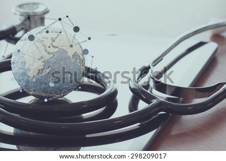 stethoscope and texture globe with digital tablet with social media network diagram as medical network concept