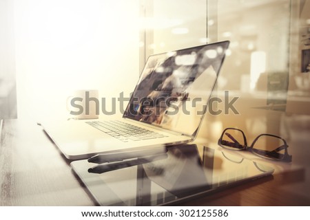 Office workplace with laptop and smart phone on wood table and london city blurred background