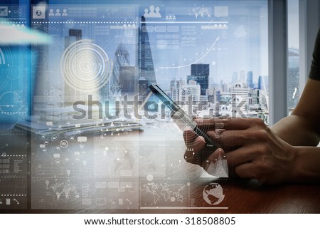 designer hand working and smart phone and laptop on wooden desk in office with london city background