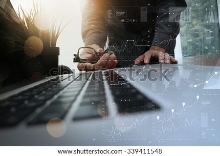 businessman hand working with new modern computer and business strategy documents digital layers with green plant foreground on wooden desk in office