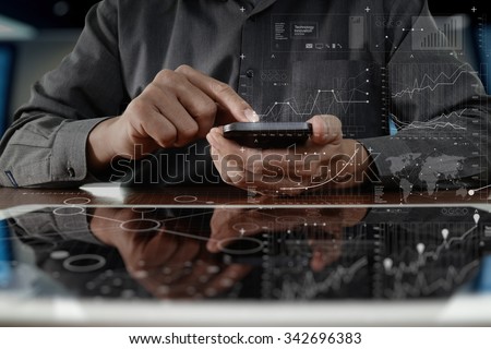 business man hand working on digital tablet computer and smart phone with digital layer business strategy and social media diagram on wooden desk