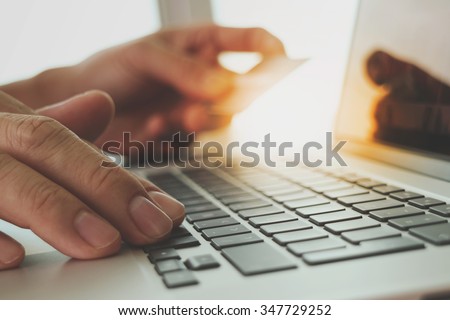hands using laptop and holding credit card with digital business layers diagram as Online shopping concept