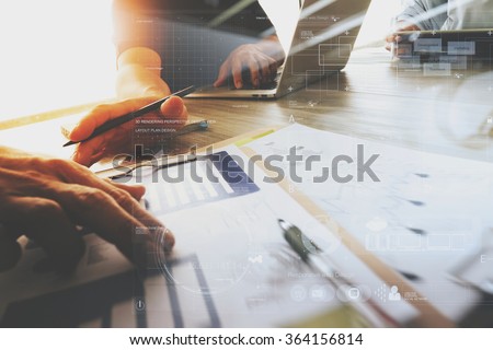 three colleagues interior designer discussing data and digital tablet and computer laptop with business document and digital design diagram on wooden desk as concept