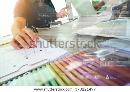 two colleagues interior designer discussing data and digital tablet and computer laptop with sample material and digital design diagram on wooden desk as concept