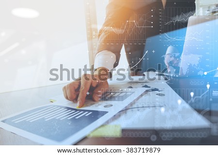 business documents on office table with laptop computer and graph business with social network diagram and man working in the background