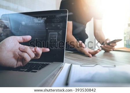 Businessman hand making presentation with his colleagues and business strategy digital layer effect at the office as concept