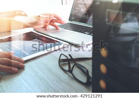 Close up photo of Designer hands working on Digital tablet laptop computer design books documents compact server. Businessman working modern office.Double exposure effects, Blurred background