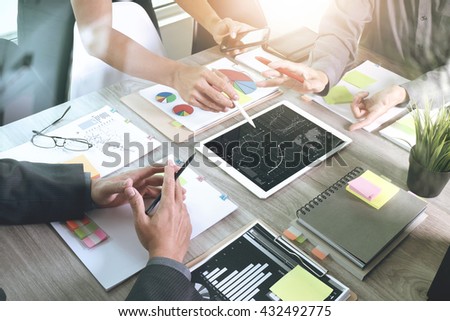 Team business meeting presentation. Hand businessman working new start up project in modern office.Laptop computer and digital table and smart phone on wood table. Horizontal, Sun flare effect photo