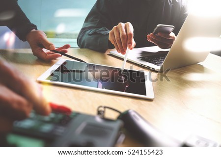 Business team meeting present. Photo professional investor working with new start up project. Finance managers meeting.Digital tablet laptop computer design smart phone using.Sun flare effect