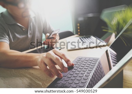 Outsource Developer working on marble Desk Working Laptop Computer Mobile Application Software and digital tablet dock smart keyboard,compact server,sun flare effect