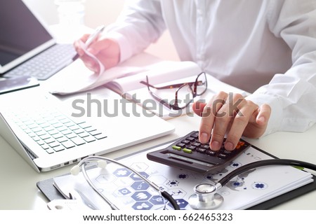 Healthcare costs and fees concept.Hand of smart doctor used a calculator for medical costs in modern hospital