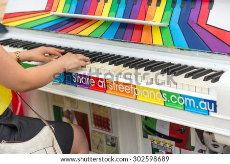Melbourne, Australia - January 10, 2014: Street Pianos, Play Me, I\'m Yours artwork, Unidentified woman play colorful rainbow piano