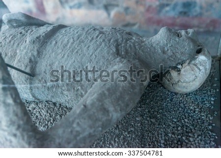 POMPEII, ITALY - November 29, 2014:Cast Body of man victim preserved in plaster cast who died in AD 79 Mount Vesuvius Volcano eruption. Close up of head and torso with part of skull and teeth exposed.